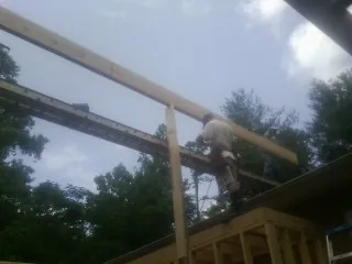 Carpenter setting a ridge beam over a new addition frame — Ice Dam Removal by Roofing Brothers in Turin