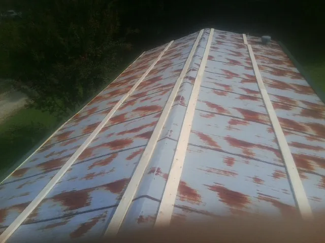 Rusted metal roof panels with new wood purlins before replacement — Storm Damage Roof Repair in Turin by Roofing Brothers