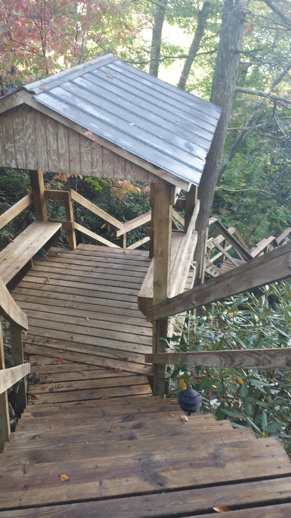 Metal roofed shelter over wooden steps on a wooded walkway — Skylight Repair & Installation work by our crew in Turin