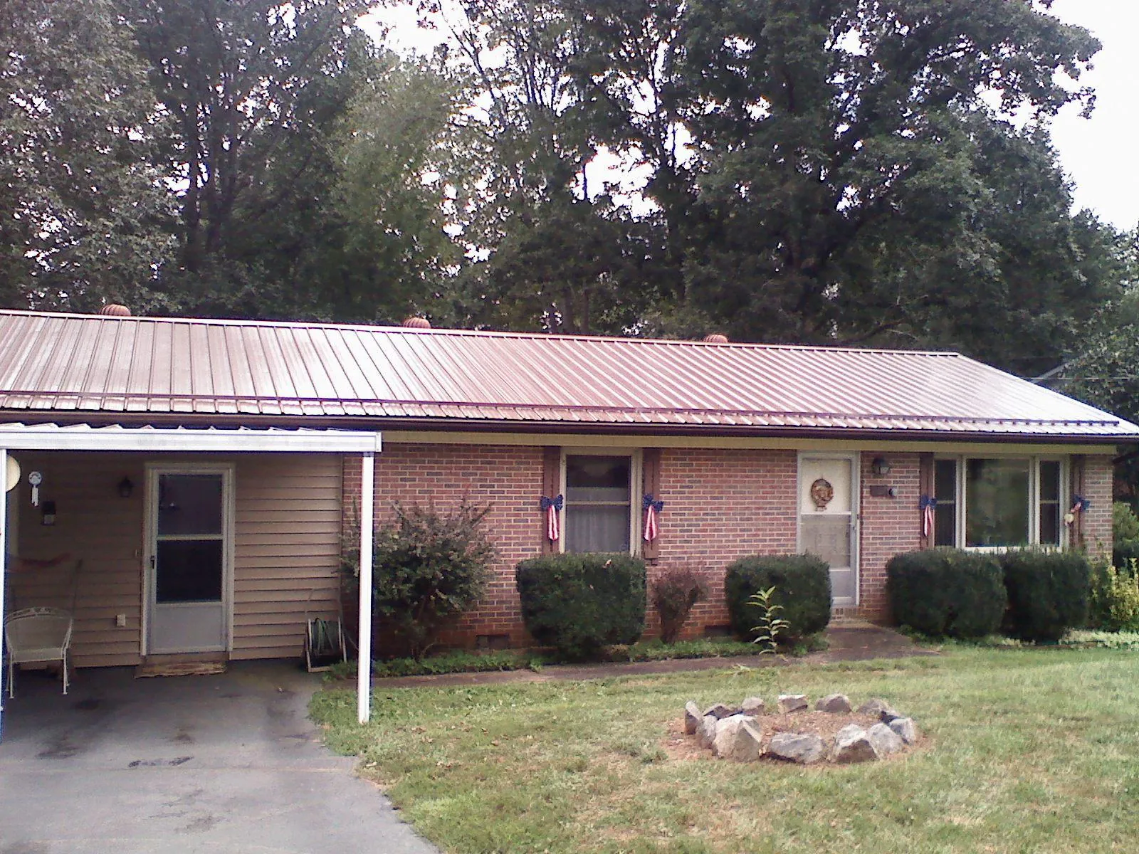 Bronze metal roof and carport on a brick ranch home — Roof Repair work by our crew in Turin